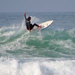 Alumno clase de surf avanzado cogiendo olas